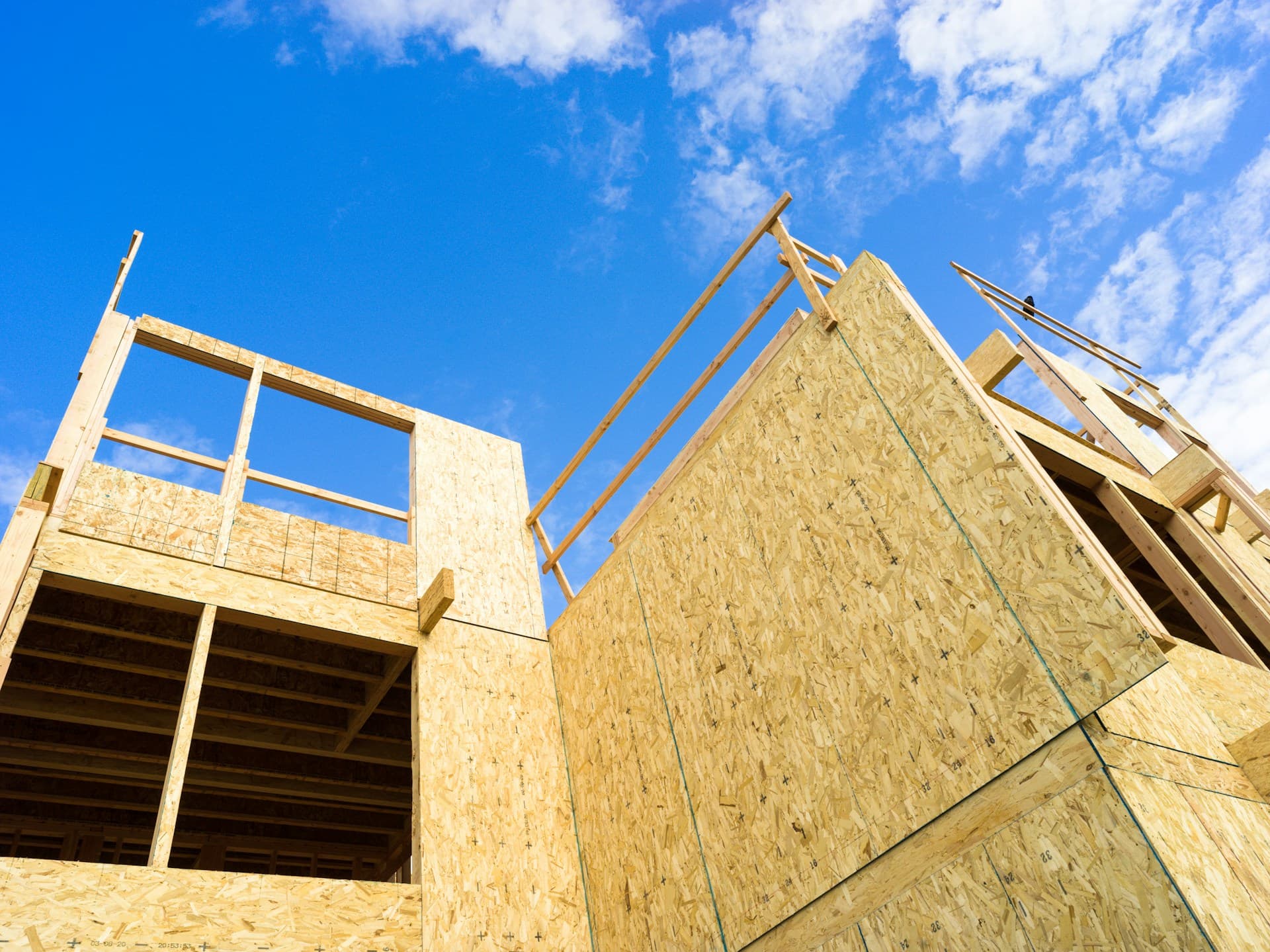 timber-framed building under construction against a blue sky